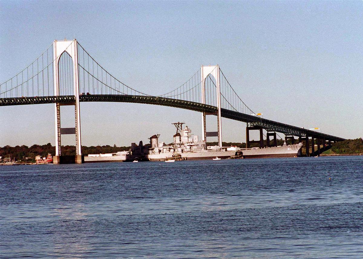 Media File No. 80266 The decommissioned battleship Iowa (BB 61) passes under the Newport Bridge on its way to join the decommissioned aircraft carriers Forrestal and Saratoga at the Naval Education and Training Center, Rhode Island. The three deep draft ships were moved by the US Navy from Philadelphia as a result of the Base Realignment and Closure (BRAC) decision to close the former Philadelphia Naval Shipyard