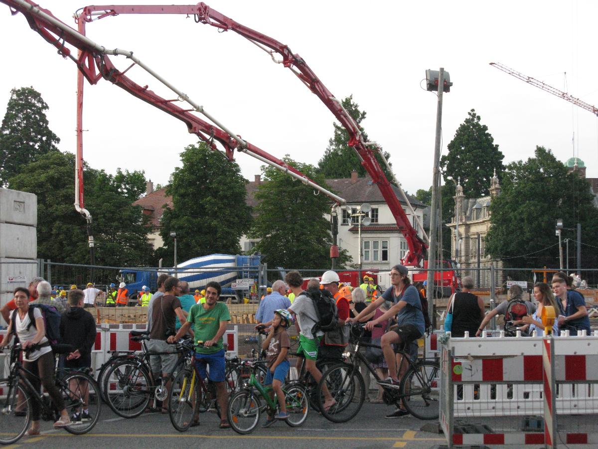 Betonierung der Freiburger Kronenbrücke, Schaulustige und Radfahrer am Überweg 