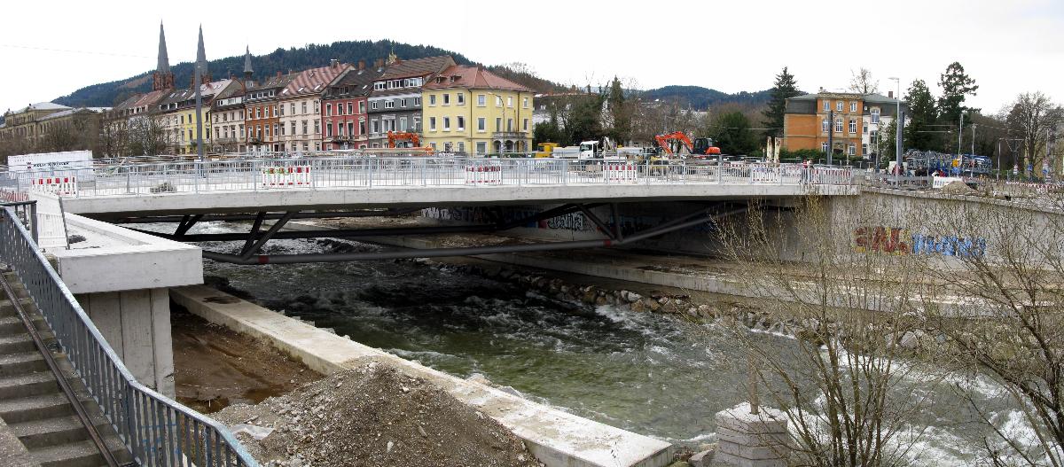 Neubau der Kronenbrücke in Freiburg Die neue Kronenbrücke in Freiburg mit Geländer von Westen gesehen, sie wird schon von Fußgängern und Radfahrern benutzt, im Hintergrund die Türme der Johanneskirche