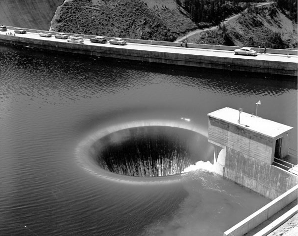 Hungry Horse Project, Montana Photograph Number P447-100-575. View of Hungry Horse Dam "glory hole" spillway, passing 30,000 cubic feet of water per second--about 225,000 gallons per second.