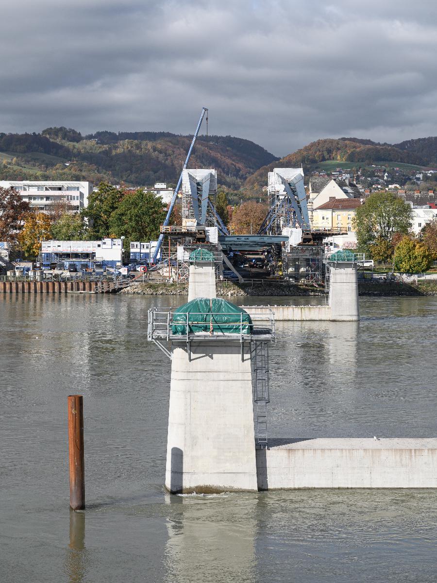 Neubau Eisenbahnbrücke Linz Die Neue Linzer Donaubrücke (Projektname) ist der Ersatz der 2016 abgetragenen Eisenbahnbrücke. Sie wurde nach einem Design des Pariser Architekturbüros Mimram gebaut. Die Vormontage erfolgte an linken Donauufer.