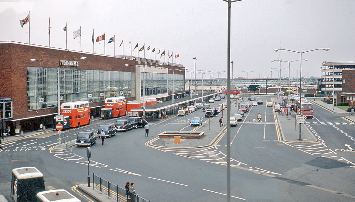 London Heathrow Airport, 1972 Elevated view southward, beside Terminal 2. The orange buses are two BEA Routemasters with their luggage trailers.