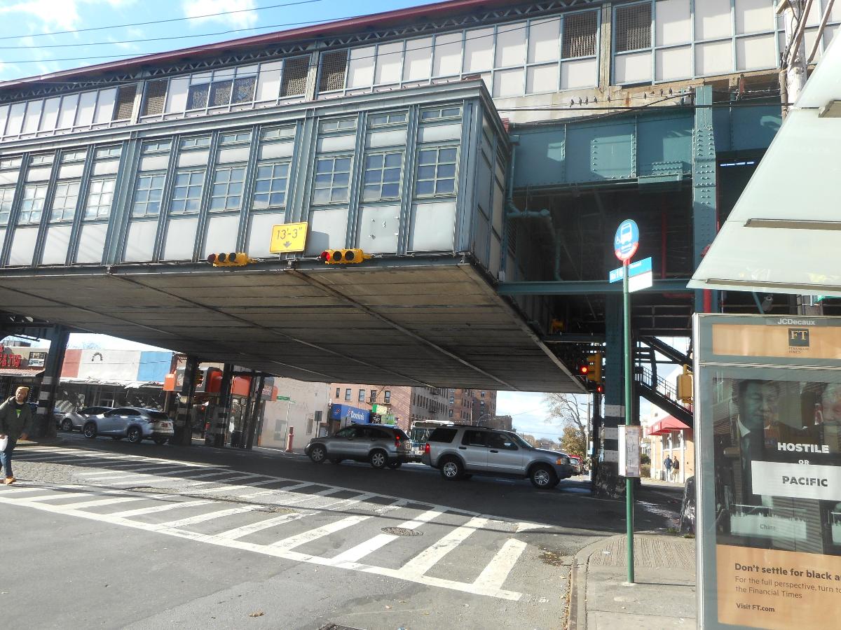 Looking west on Nereid Avenue ( former NY 164 ) at the intersection of White Plains Road under the Nereid Avenue Elevated Railway Station Located on the IRT White Plains Road Line in the Wakefield section of the Bronx, New York City. A bus stop sign also exists here.