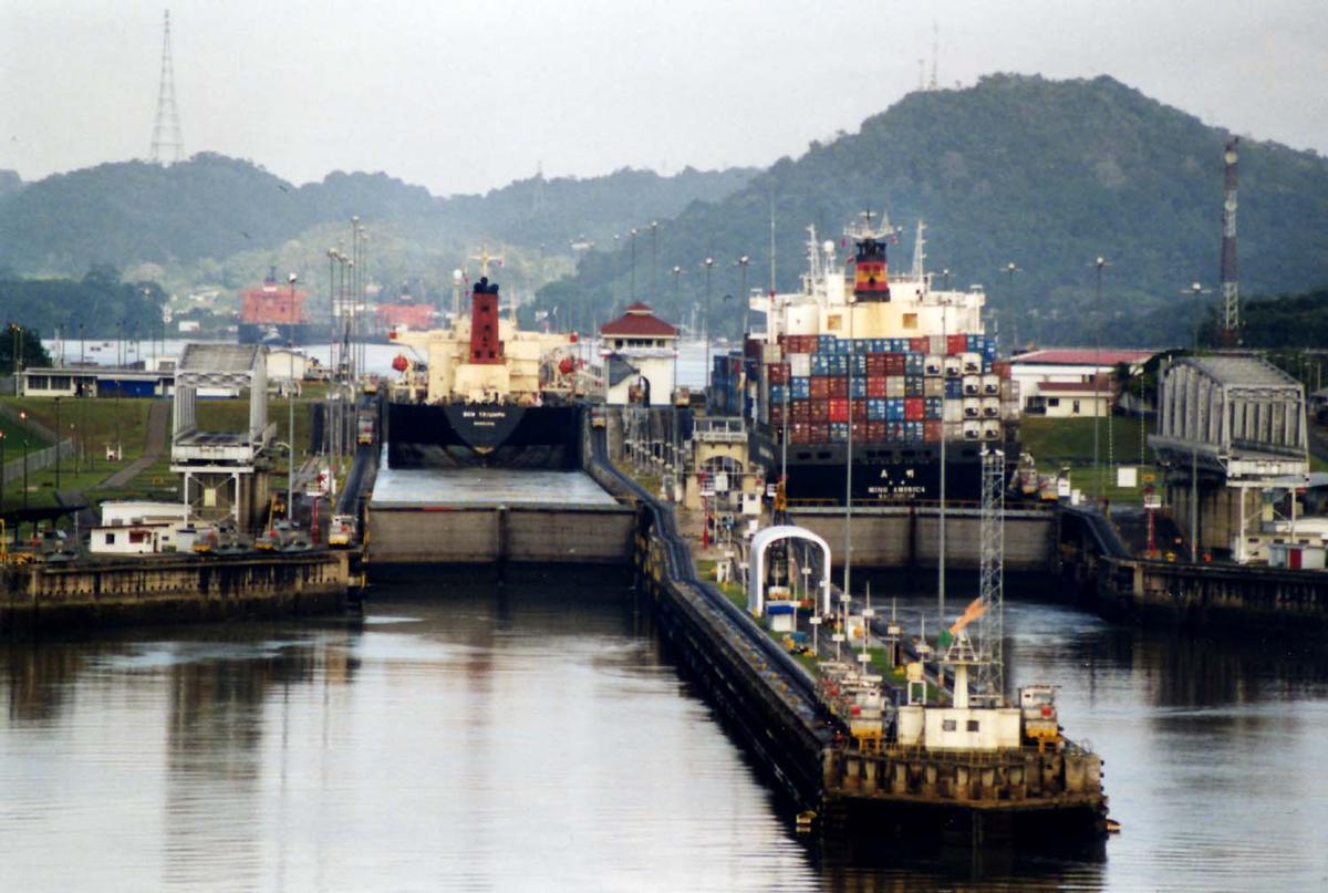 Media File No. 209481 Panama Canal Miraflores Locks, looking northwards, towards Miraflores Lake, with the Pedro Miguel locks visible in the background. In the foreground, on the end of the approach wall, a large illuminated arrow can be seen; this rotates to indicate to ships which chamber they are to enter