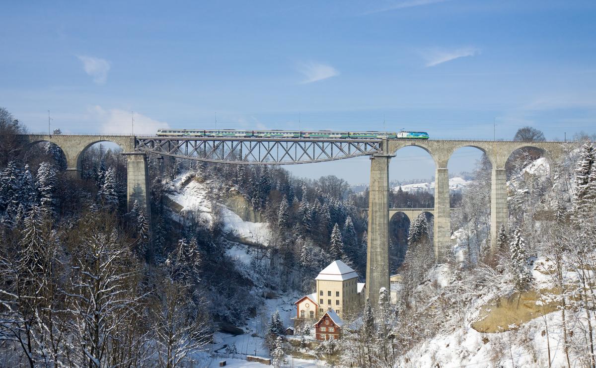 Mediendatei Nr. 211910 Das Sittertobelviadukt ist die höchste normalspurige Eisenbahnbrücke Europas. Die Schienen befinden sich 99 m über dem Wasser. In diesem Bild überquert gerade ein stündlicher Voralpenexpress (Luzern - Romanshorn), gezogen von einer Re 456 der Südostbahn den Viadukt