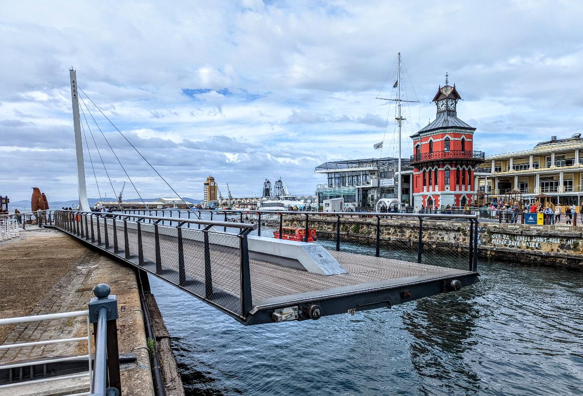 The Clocktower Bridge, a swing bridge at the Victoria and Alfred Waterfront in Cape Town, South Africa, as it starts to close behind a small boat 