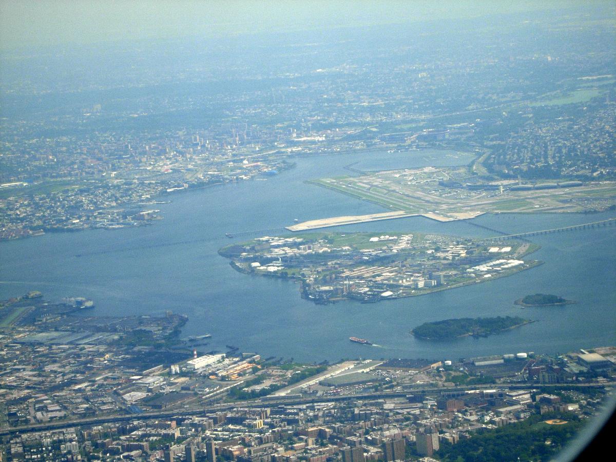 A view of Rikers Island in New York, United States, looking south from the air over The Bronx. LaGuardia Airport can be seen in the background. Flushing Bay, Shea Stadium and Citi Field can be seen slightly behind LaGuardia. Vernon C. Bain Correctional Center can be seen in the lower left as the blue and white docked prison barge. The Hunts Point Wastewater Treatment Plant is located to the right of the Bain Correctional Center.